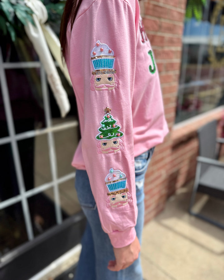 Holly Jolly Sweatshirt: pink sequin sweatshirt with embroidered cupcakes and a Christmas tree on the sleeve. Available in sizes S-XL.