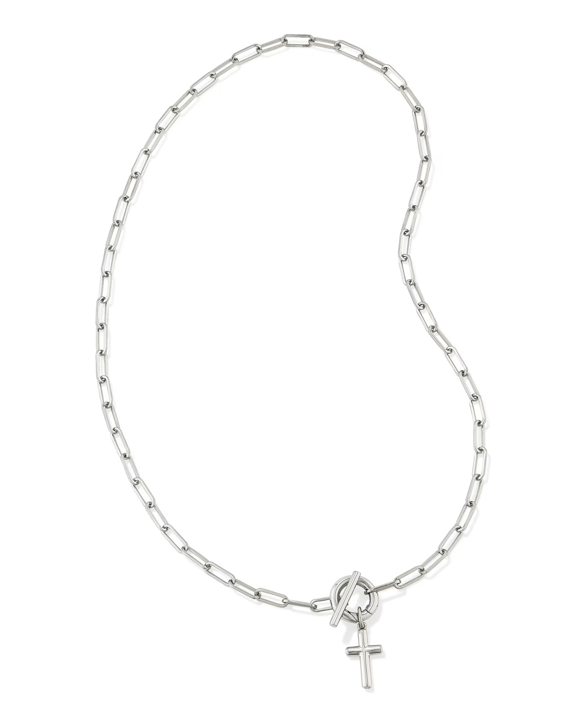Silver chain necklace with rectangular links, toggle clasp, and small cross pendant near the clasp. Available in 16" and 18".