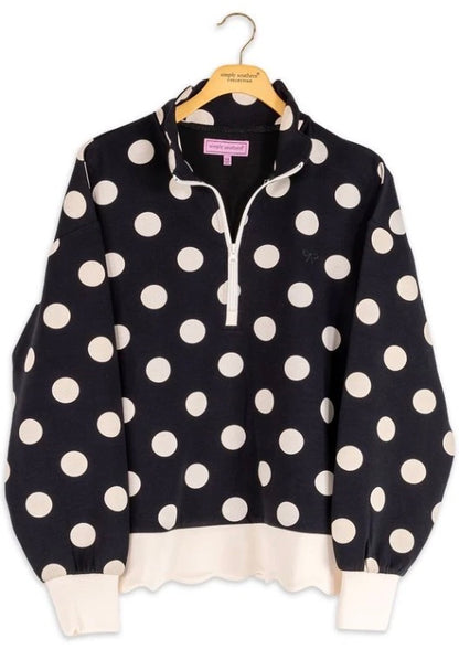Black quarter zip pullover sweater with large white polka dots, white cuffs, and hem. Available in sizes XS-XL.