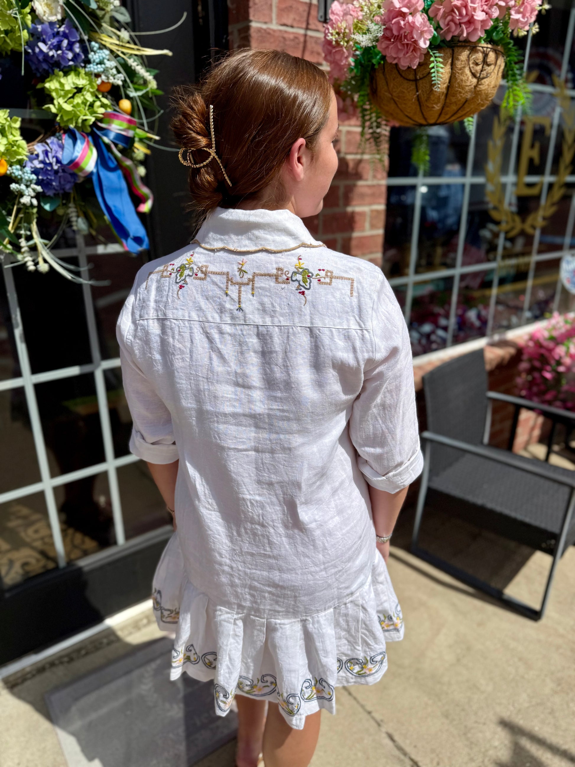White Table Linens Dress with embroidery and ruffled hem. Available in sizes XS–XL.