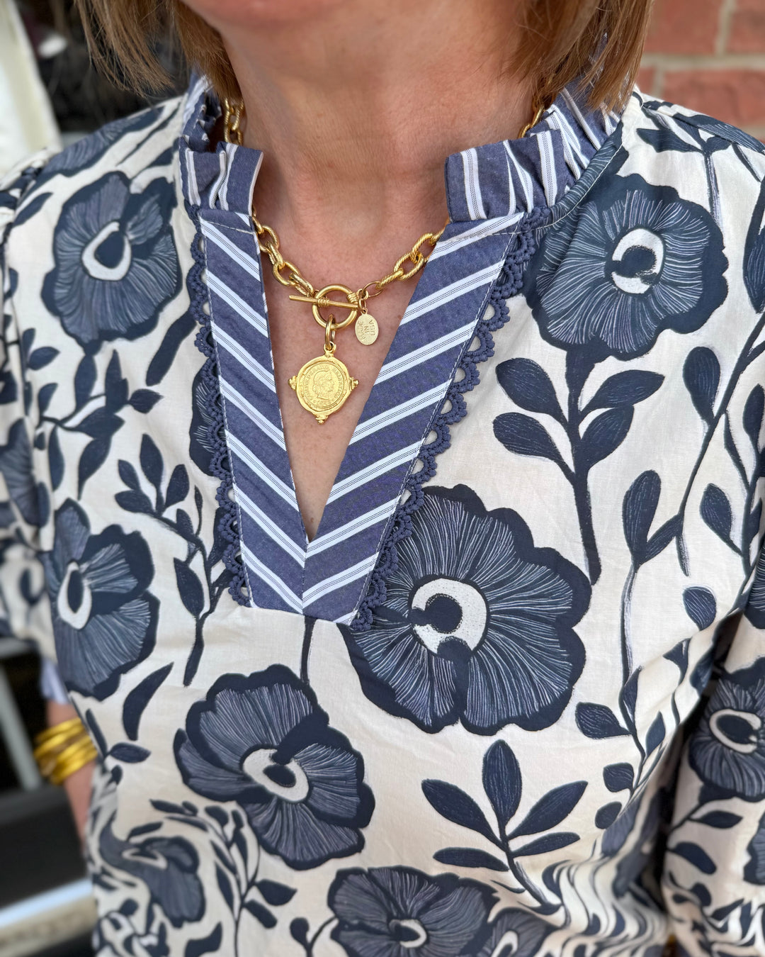 Bonnie Ruffle Floral Blouse with blue and white floral print and striped collar; available in sizes XS–XL.