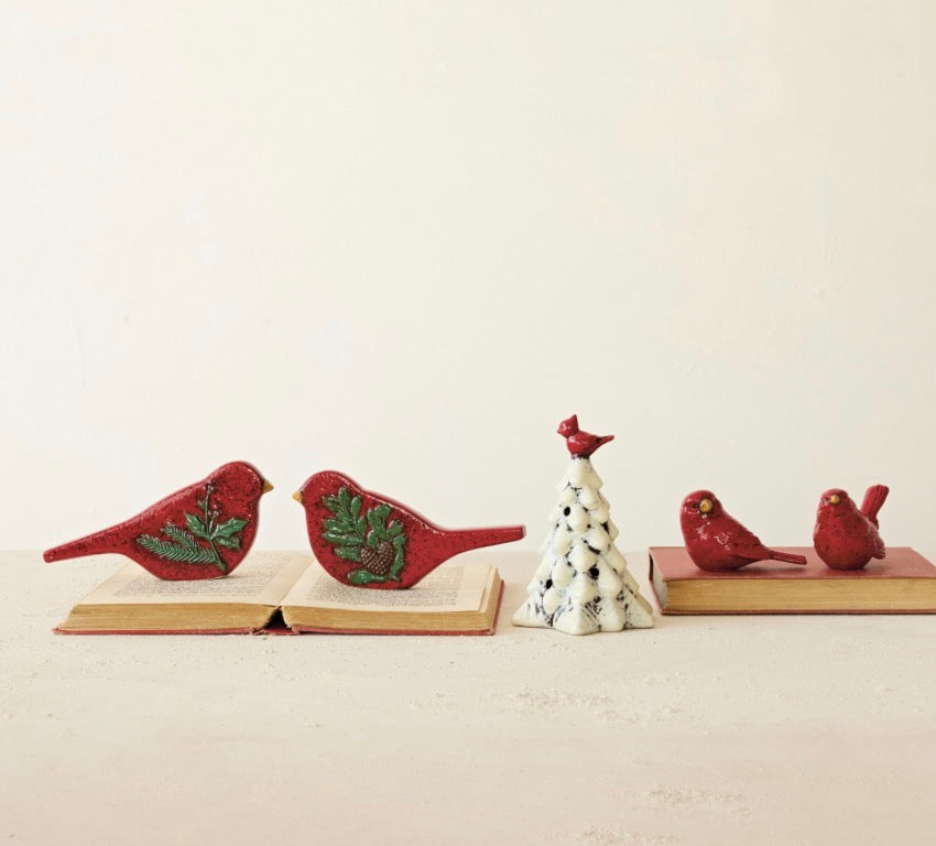 Two hand-painted embossed ceramic bird figurines in red and yellow, decorated with pine branches and pinecones.