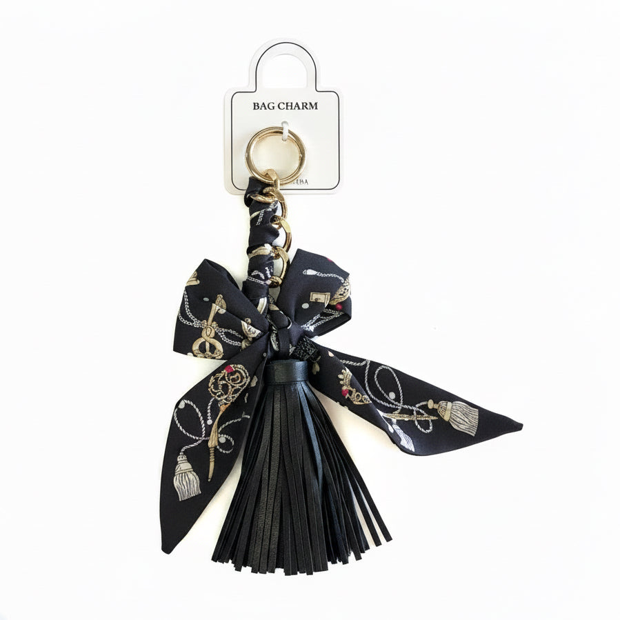 Black tassel and black ribbon with gold and silver patterns attached to a gold keyring. Available sizes not specified.