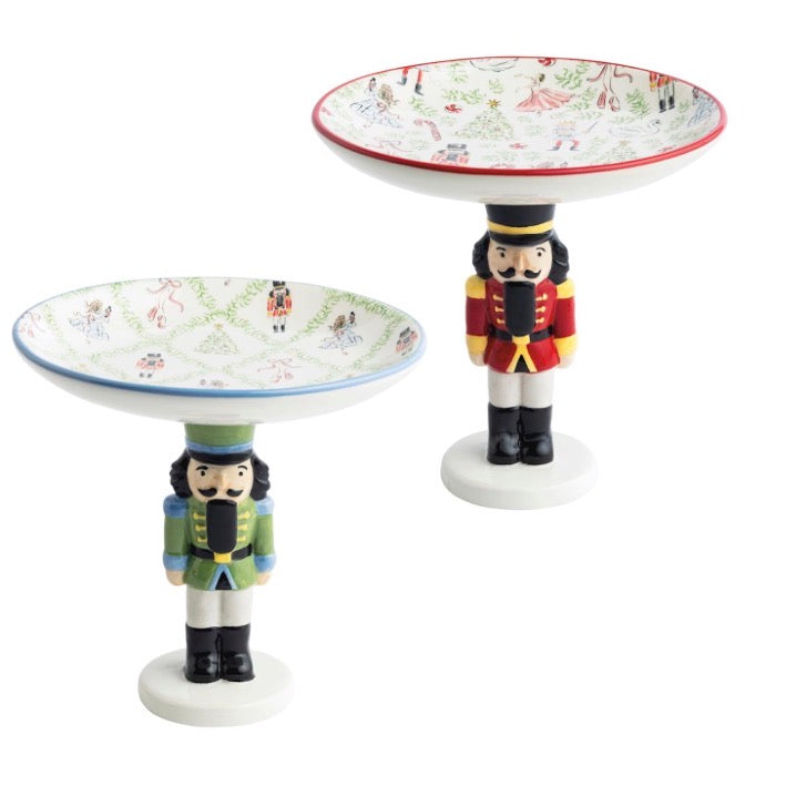 Two Nutcracker candy dishes with standing figure bases and holiday-patterned bowls.