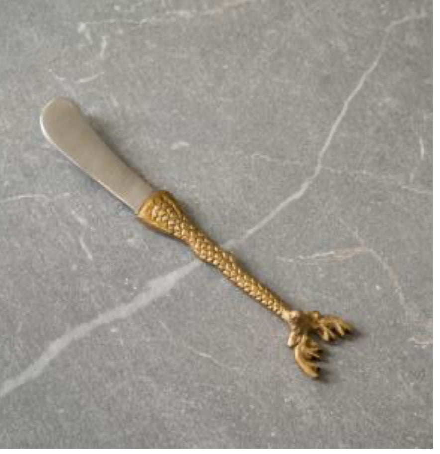 Gold Deer Spreader: Intricately detailed handle resembling a bird's leg and claw in gold, with a silver blade. Sizes available: N/A.