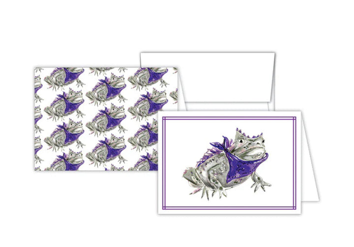 Petite Notes Handpainted set includes two greeting cards with a detailed illustration of a frog in a purple bandana. One card features the frog image framed, and the other displays it in a repeated pattern. Perfect for snail mail enthusiasts. Sizes available: Not specified.