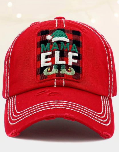 Red distressed baseball cap with white stitching, green elf hat patch, "MAMA ELF" text, and embroidered elf shoes. Sizes: One Size.