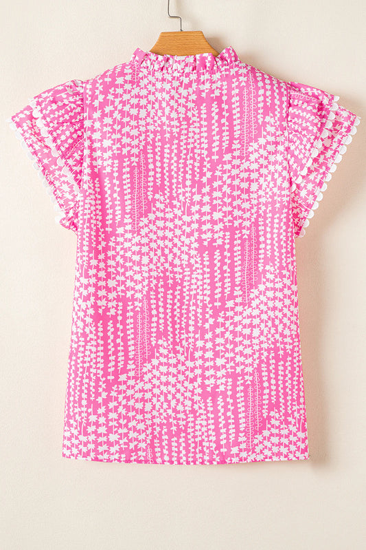 Pink blouse with abstract print, ric rac trim, notch V-neck, pompom-trimmed flutter sleeves. Available in sizes XS-XL.