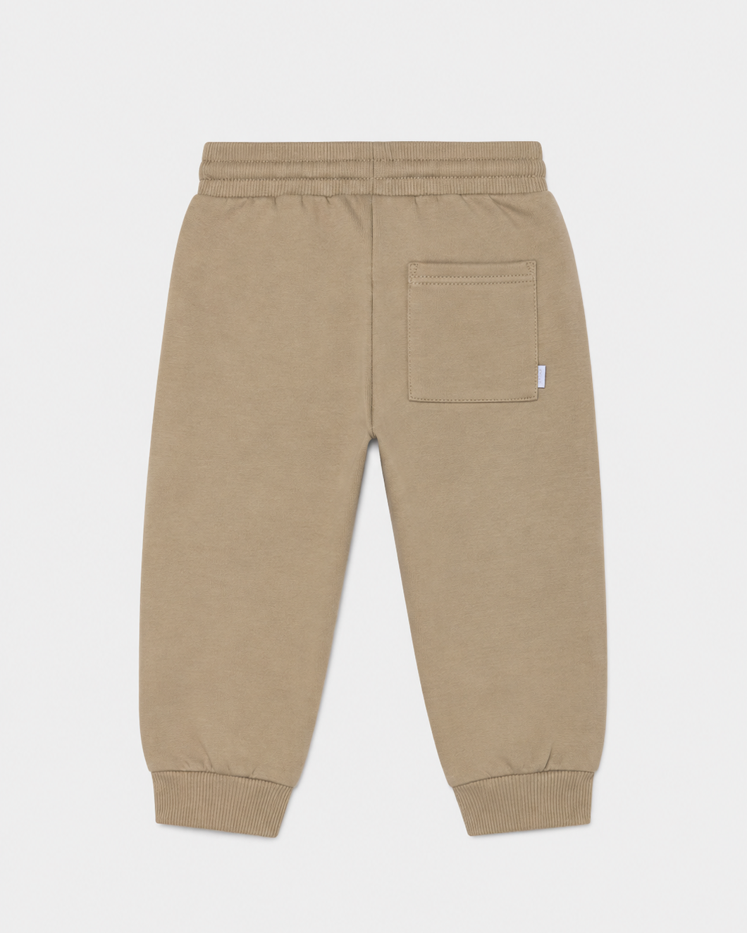 Hazelnut brown baby jogger pants with elastic waistband, ribbed cuffs, and a single right-side back pocket. Available in sizes 0-3M, 3-6M, 6-12M.