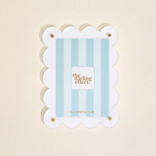 Clear mini acrylic frame magnet with gold corner screws, fits 2x3 photos or film. Scalloped edge design. Size: 2x3 inches.