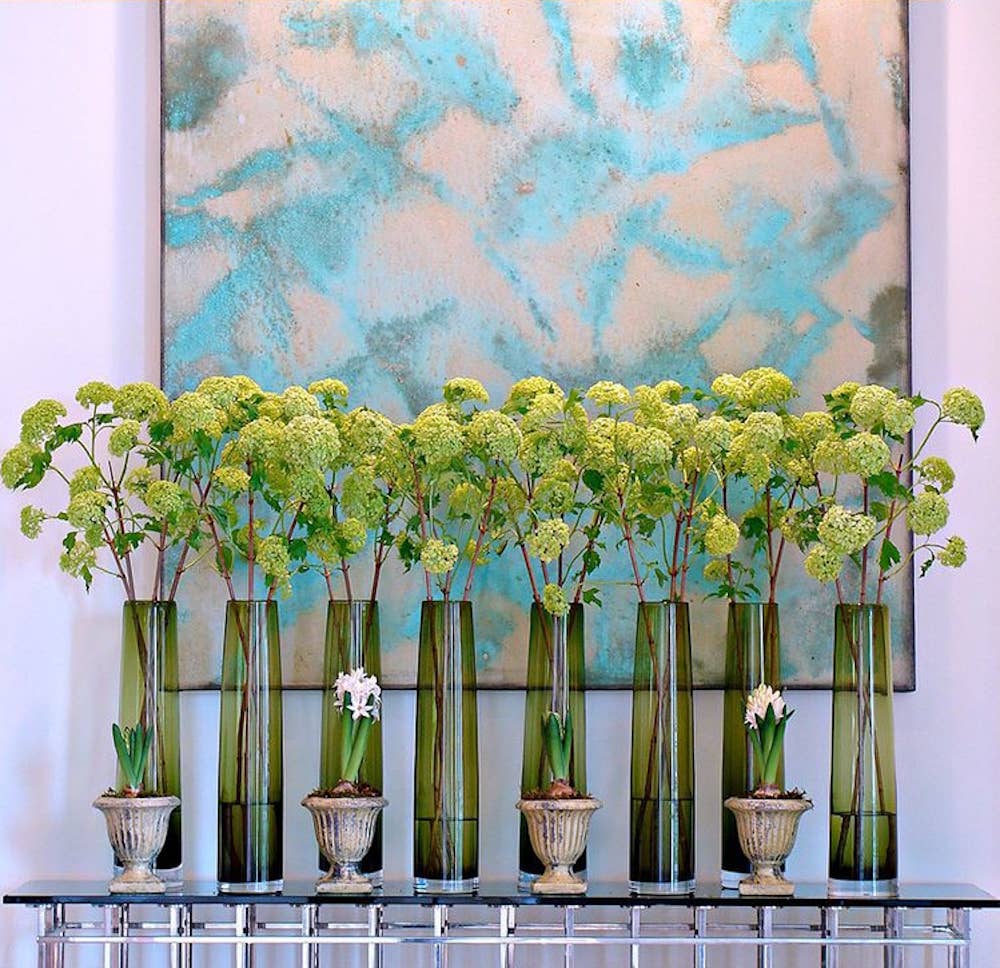 Contemporary arrangement with tall green vases and light green flowers, featuring 40" long faux snowball hydrangea spray. Sizes: 5 blooms per spray.