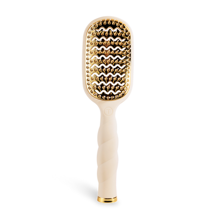 The Vented Hair Brush | Tan is a beige blowout brush with a gold-toned vented paddle, quick-heat aluminum plate, and twisted handle. Available in standard size.