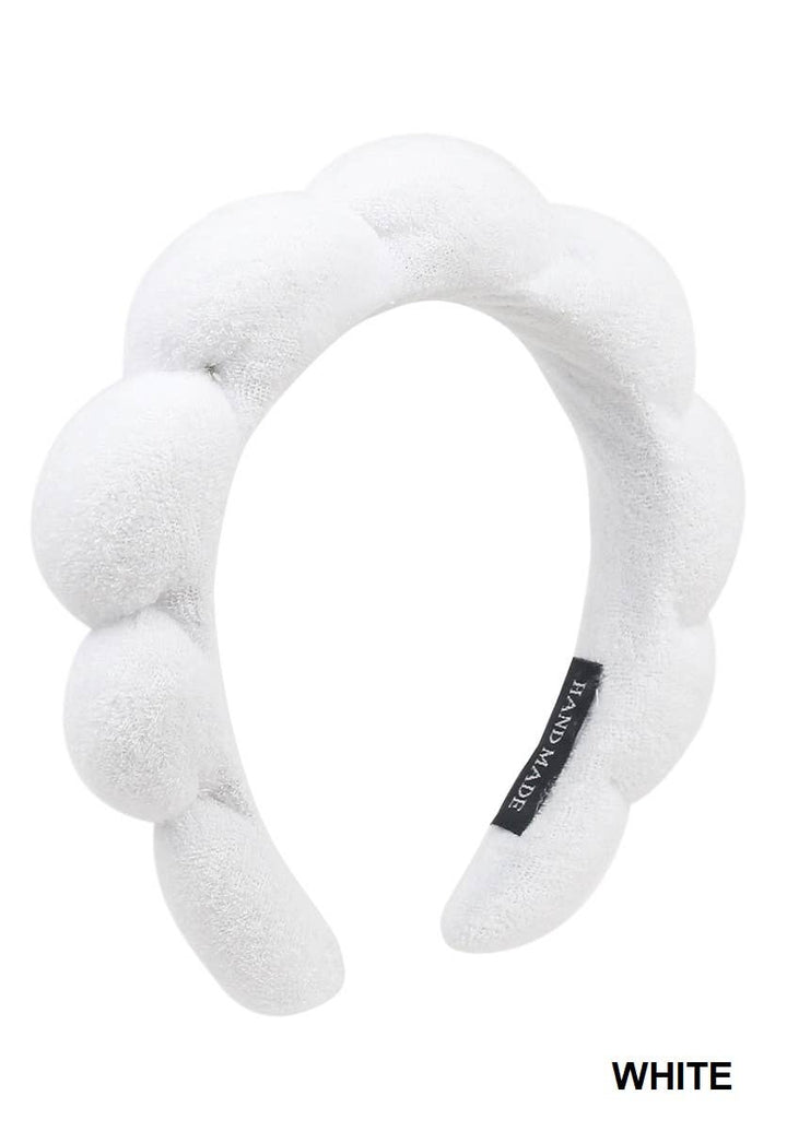 Soft, absorbent white terry hair headband with textured, bubbly design, small black label. Sizes available: S/M, M/L.