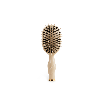 Compact beige Mini Boar Brush | Tan with black and white-tipped bristles, twisted handle. Available in a travel size.