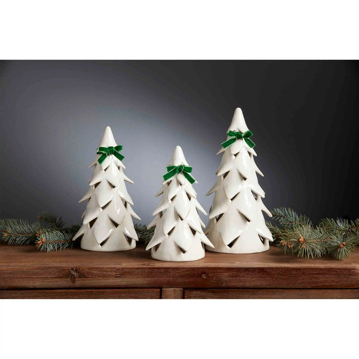 Three white ceramic Christmas tree sitters with green bows, in varying sizes.
