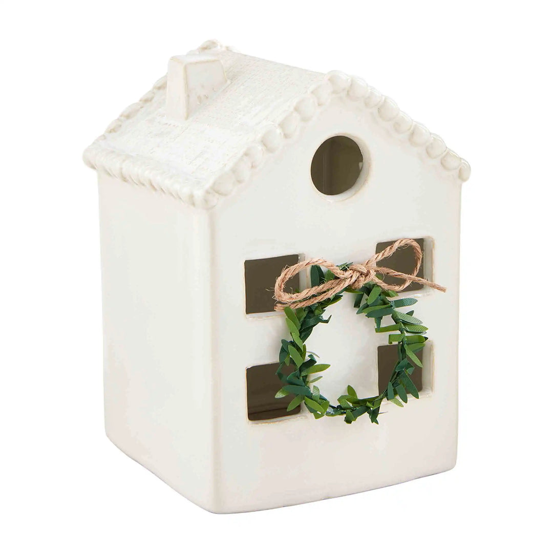 White Christmas House, off-white stoneware figurine with milk glaze and a small decorative wreath.