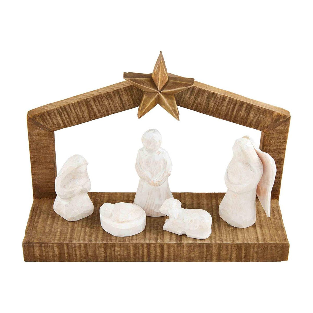 White Christmas Nativity set with Holy Family and lamb figurines under a wooden stable frame.