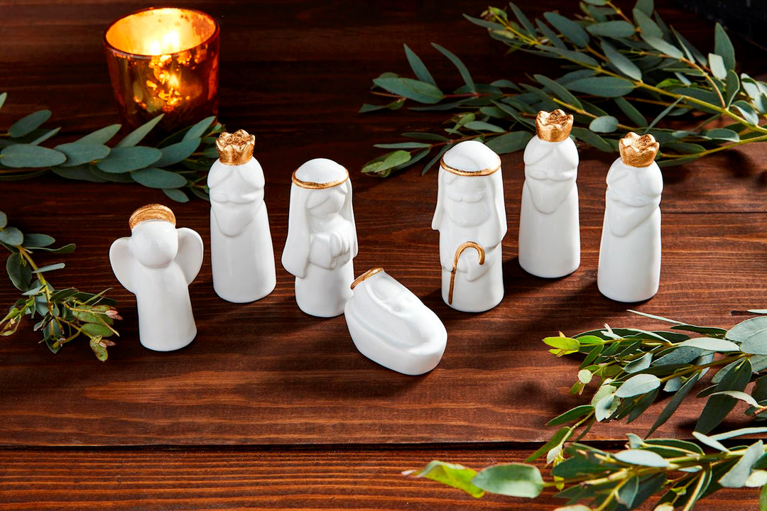 Boxed set of six small white ceramic stoneware Nativity figures with gold electroplate detail.