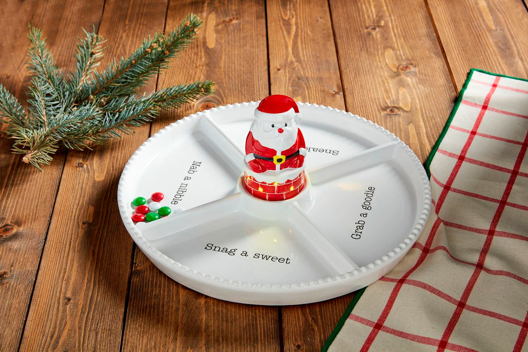 Divided white serving platter with a center Singing Light-Up Santa Sitter and labels “Nab a nibble,” “Grab a goodie,” and “Snag a sweet.”.