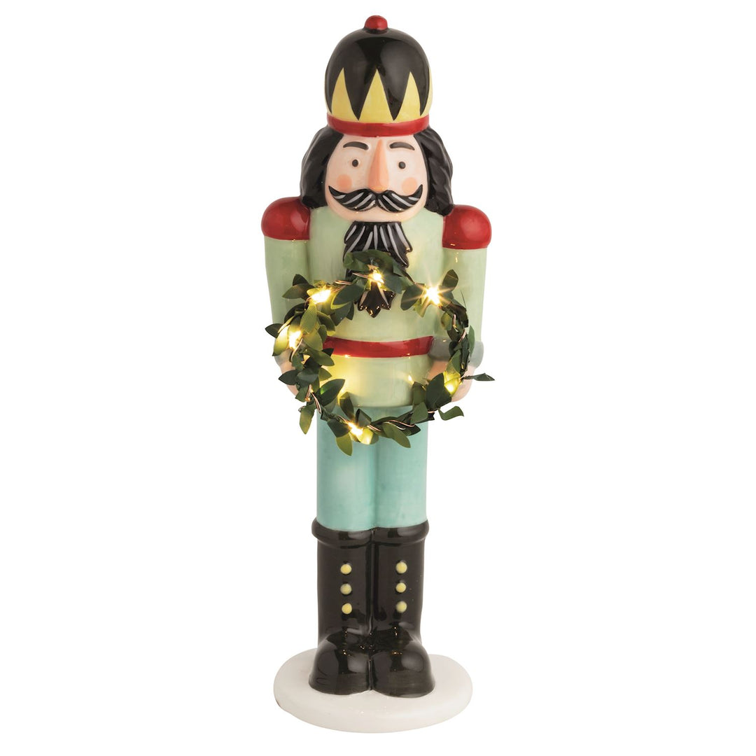 Hand-painted ceramic LED nutcracker sitter holding a miniature light-up faux wreath.