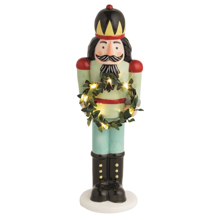 Hand-painted ceramic LED nutcracker sitter holding a miniature light-up faux wreath.