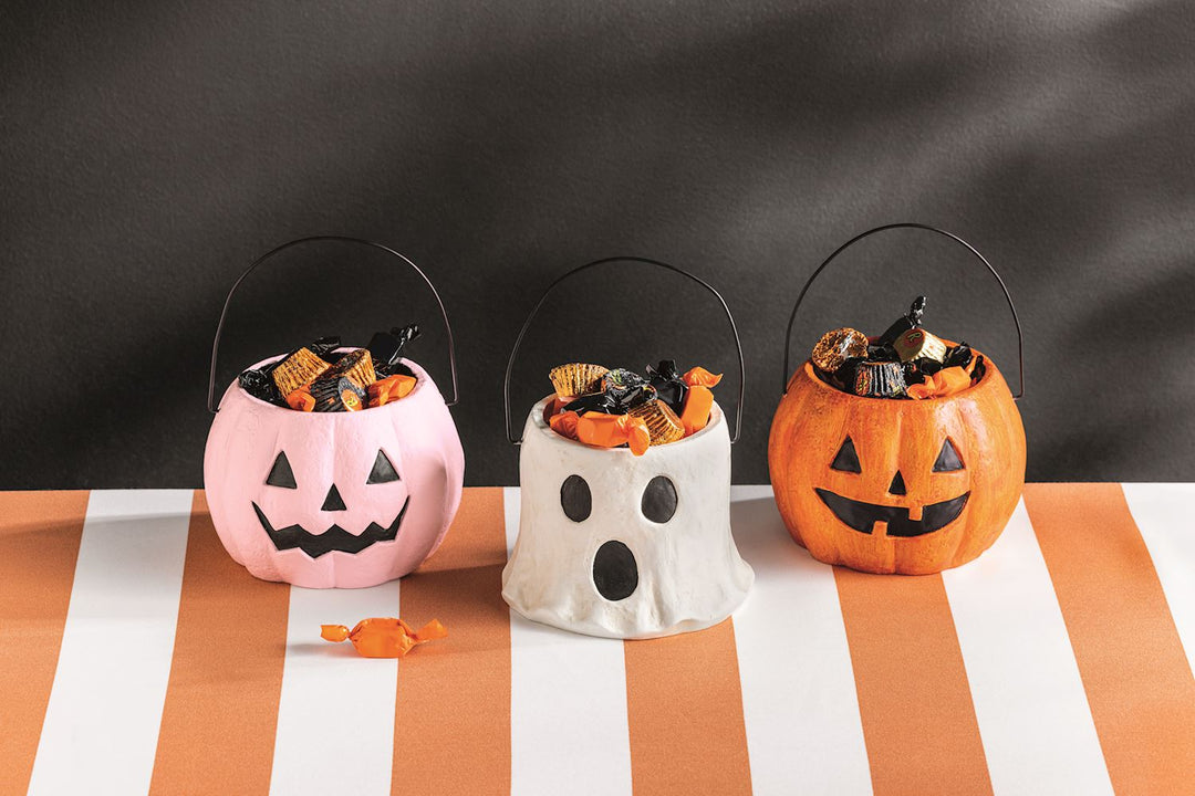 Three hand-painted Mini Halloween Treat Buckets in pink pumpkin, white ghost, and orange pumpkin styles, each filled with assorted candies. Available in small size.
