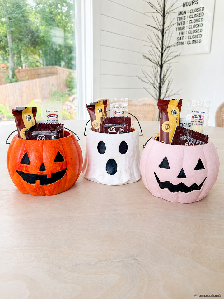 Three Mini Halloween Treat Buckets—orange pumpkin, white ghost, and pink pumpkin—each filled with Japanese KitKat candy. Available in mini size.