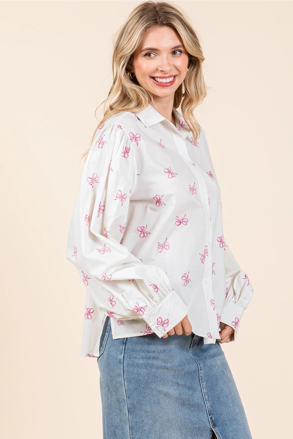 The Ribbon Bow Print Button-Up Blouse features a playful pattern with button-up front. Sizes available: XS, S, M, L, XL.