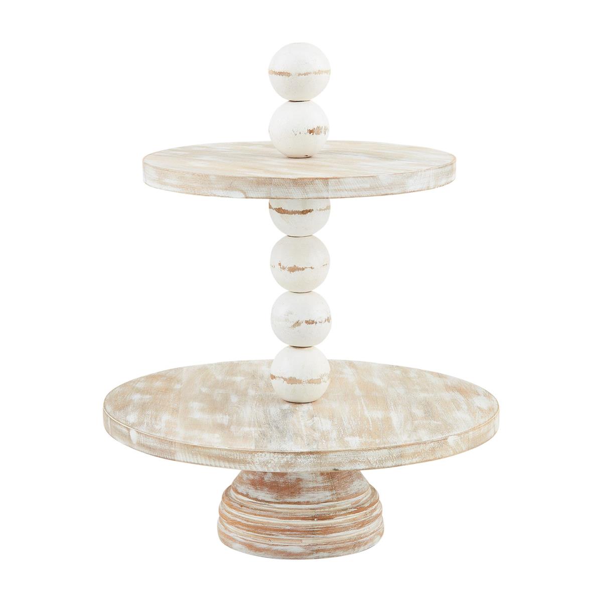 The Chunky Beaded Tiered Server features two rustic, round trays made of distressed white mango wood, connected by a column of wooden spheres. Ideal for serving or decorative use. Available sizes: 18" diameter and 2-tier height.