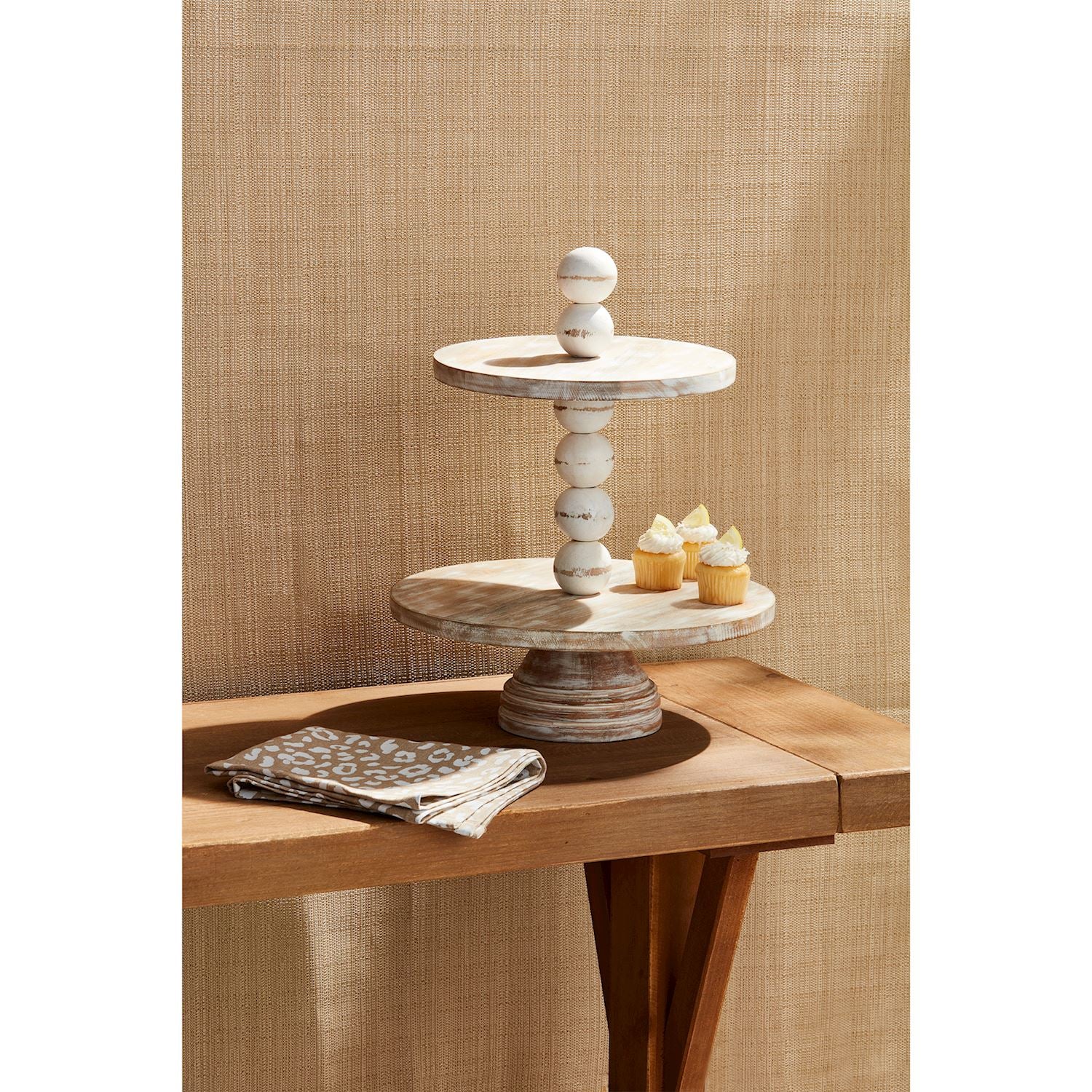 The Chunky Beaded Tiered Server features a two-tiered design with mango wood and marble, ideal for displaying cupcakes. Sizes available: One size.