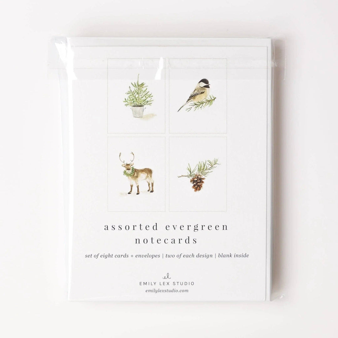 The Evergreen Christmas assorted notecard set includes eight blank notecards with envelopes, each featuring watercolor illustrations of a pine sprig, bird, reindeer, or pine tree. Sizes available: standard notecard.