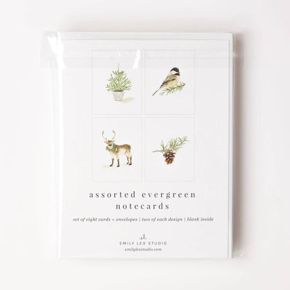 The Evergreen Christmas assorted notecard set includes eight blank notecards with envelopes, each featuring watercolor illustrations of a pine sprig, bird, reindeer, or pine tree. Sizes available: standard notecard.