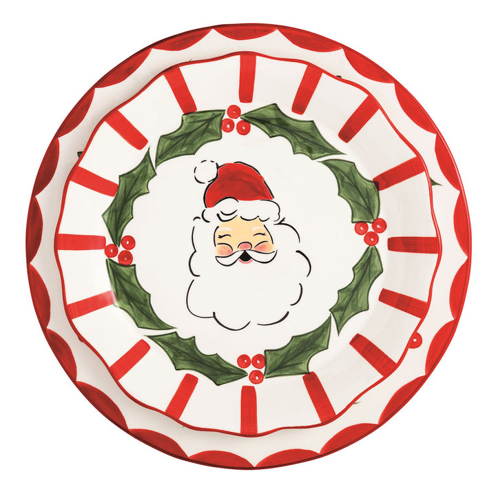 Two hand-painted ceramic Holly Santa platters with Santa face, holly wreath border, and red and white scalloped rim.