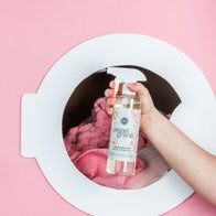 Sweet Grace Stain Remover bottle held in hand; product available in 16 oz and 32 oz sizes.