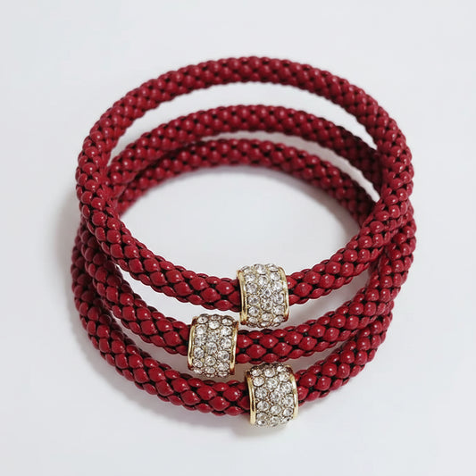 Three red braided bracelets with gold and diamond-encrusted clasps. Available sizes: small, medium, large.