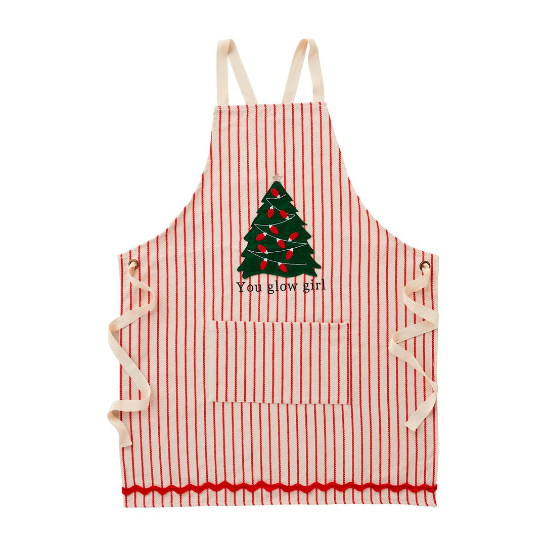Red and white striped chambray Christmas Light-Up Aprons with a tree graphic, “You glow girl” text, and a front pocket.