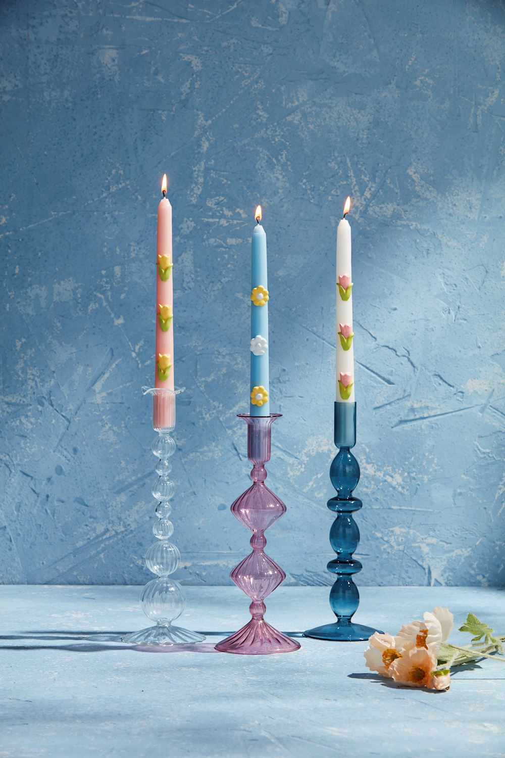 Three lit candles with colored patterns in hand-blown Glass Taper Holders. Sizes available: Standard height for taper candles.