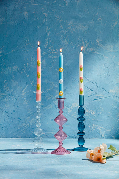 Three lit candles with colored patterns in hand-blown Glass Taper Holders. Sizes available: Standard height for taper candles.