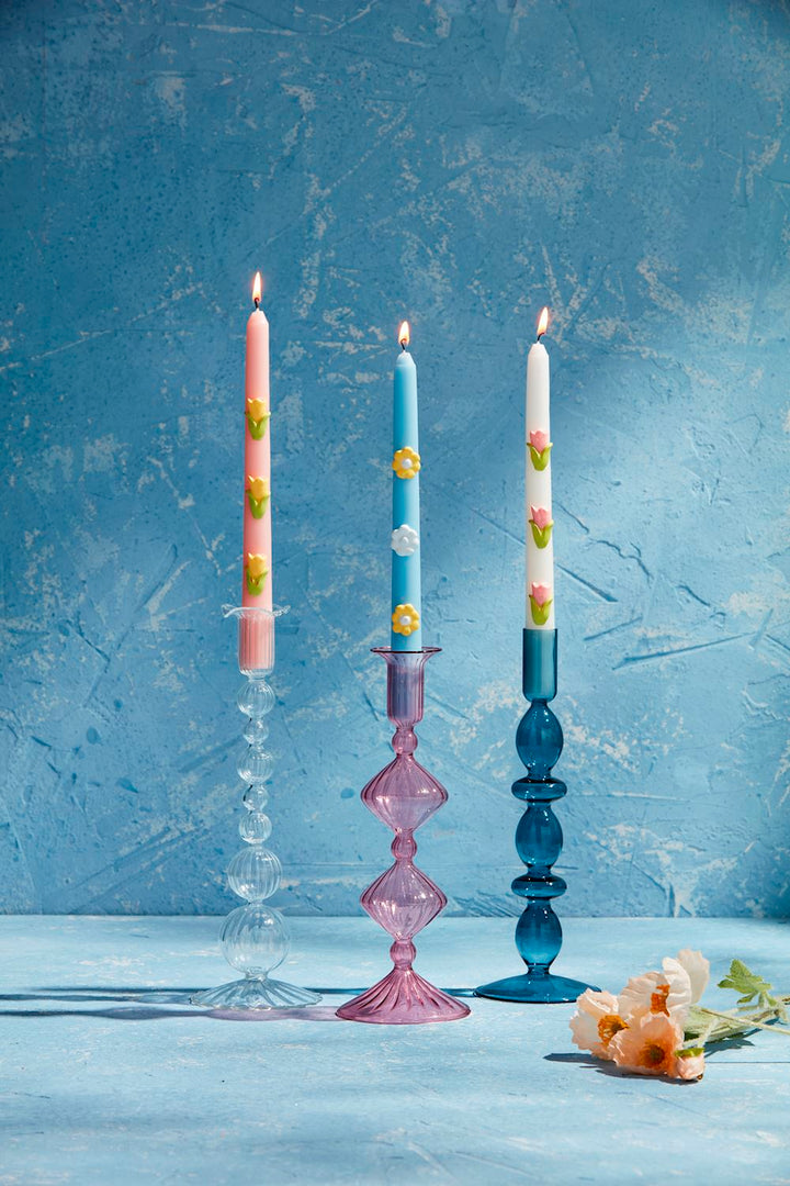 Three lit candles with colored patterns in hand-blown Glass Taper Holders. Sizes available: Standard height for taper candles.