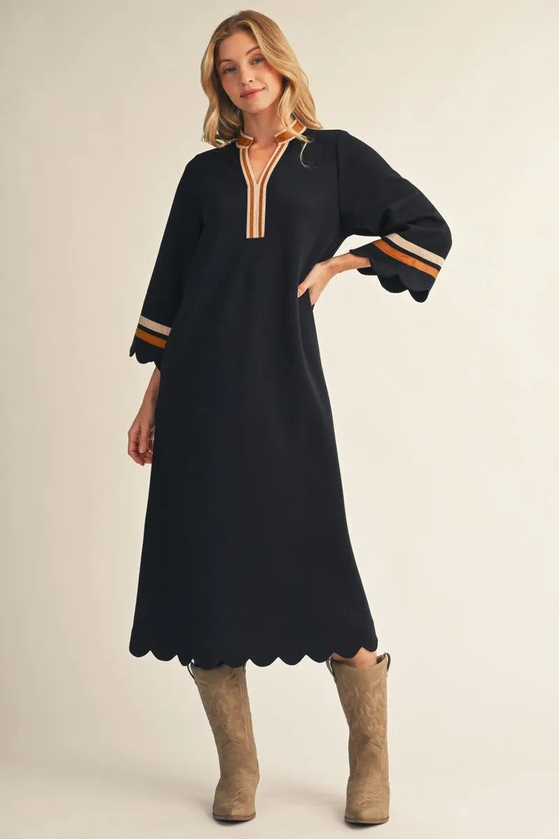 Black Solid Midi Dress With Scalloped Edges features a relaxed silhouette, scalloped edges, and orange-striped accents on the sleeves and neckline; available in sizes XS–XL.