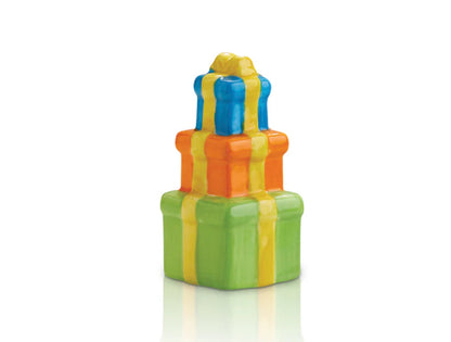 Nora Fleming Minis gift boxes with shiny yellow ribbons; sizes in decreasing order. Bottom box: green, middle box: orange, top box: blue.