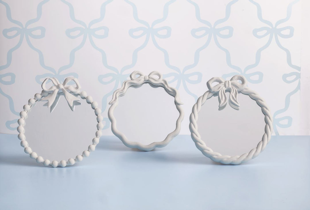 Set of three metal bow mirrors with white frames and bow toppers, each with a unique design. Available in S, M, and L.