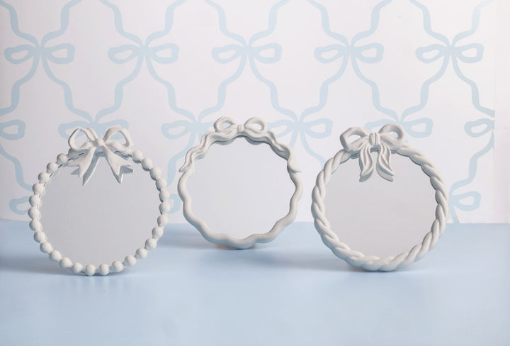 Set of three metal bow mirrors with white frames and bow toppers, each with a unique design. Available in S, M, and L.