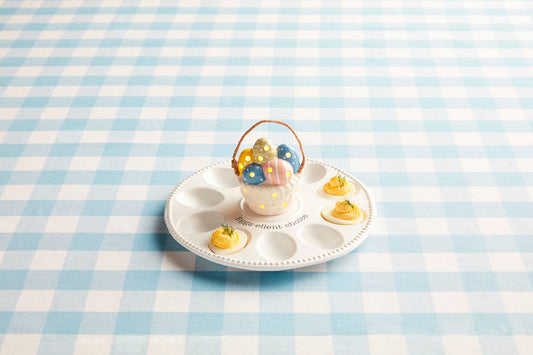 The Deviled Egg Tray Light-Up Holder features a ceramic design with space for four deviled eggs, complemented by a colorful egg holder shaped like an ornate basket. Available in one size.
