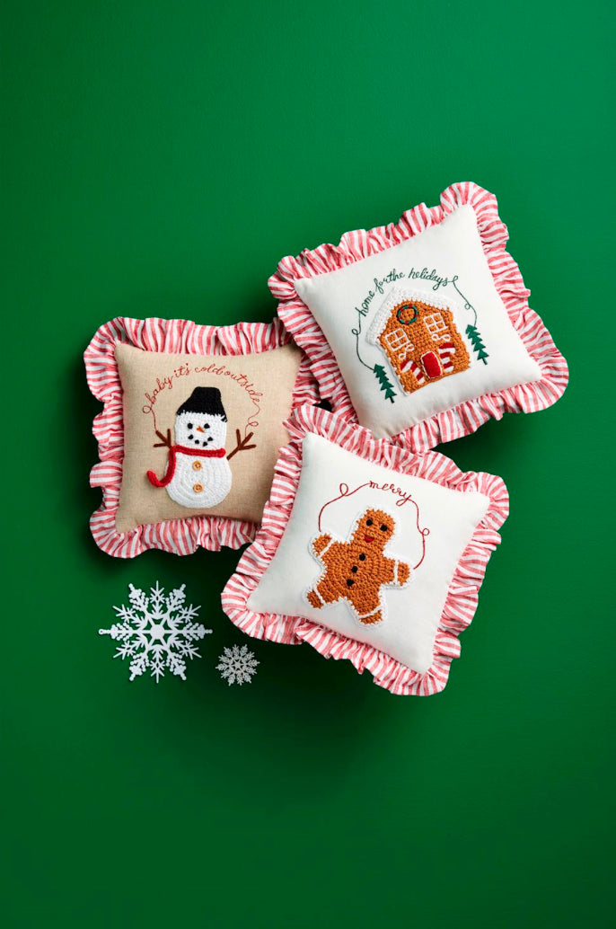 Mini Christmas crochet pillows with French ticking ruffles and embroidered snowman, gingerbread house, and gingerbread man designs.