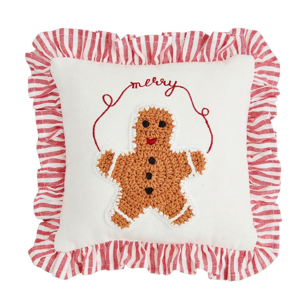 Mini Christmas Crochet Pillow. Square white throw pillow featuring a crocheted gingerbread man, red “merry” embroidery, and a red-and-white striped French ticking ruffle.