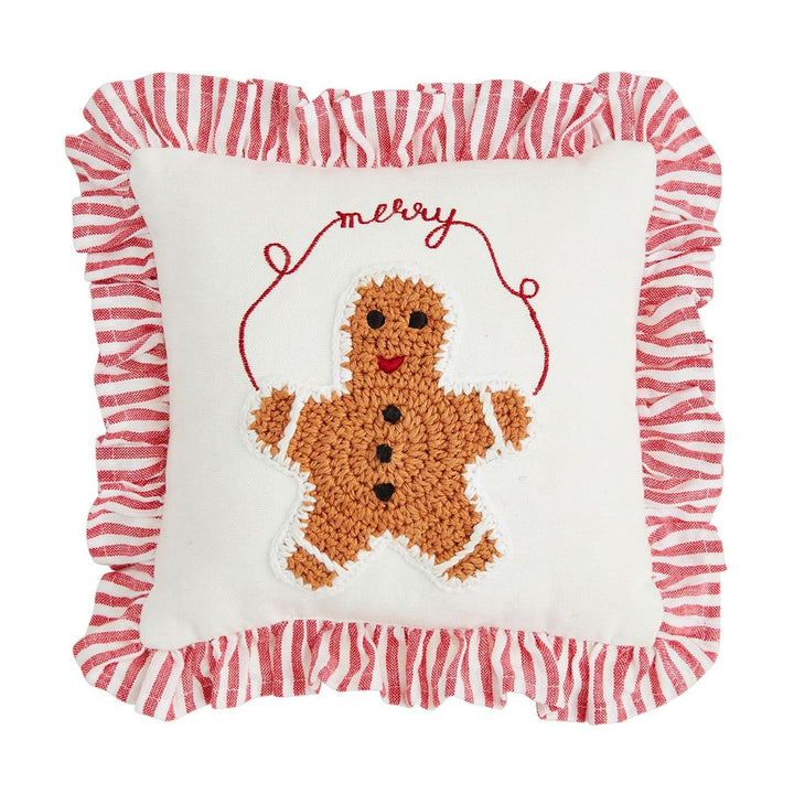 Mini Christmas Crochet Pillow. Square white throw pillow featuring a crocheted gingerbread man, red “merry” embroidery, and a red-and-white striped French ticking ruffle.