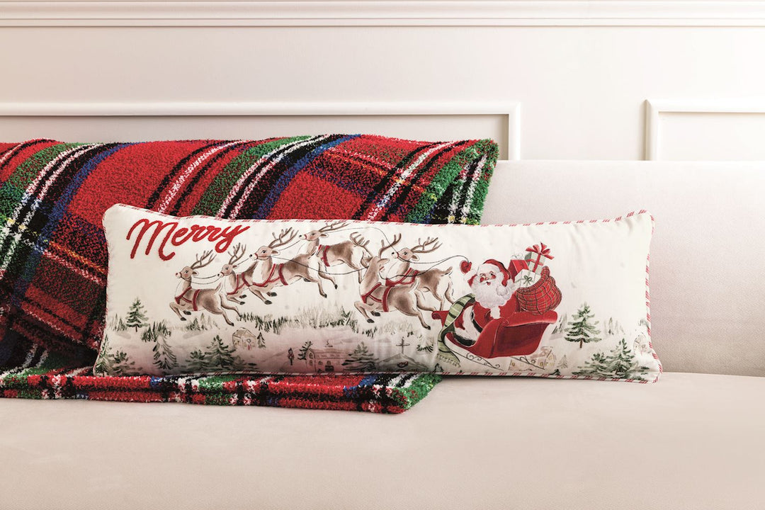 Santa Scene long pillow featuring Santa in a sleigh over a winter village with “Merry” in red script.