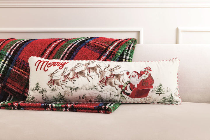 Santa Scene long pillow featuring Santa in a sleigh over a winter village with “Merry” in red script.