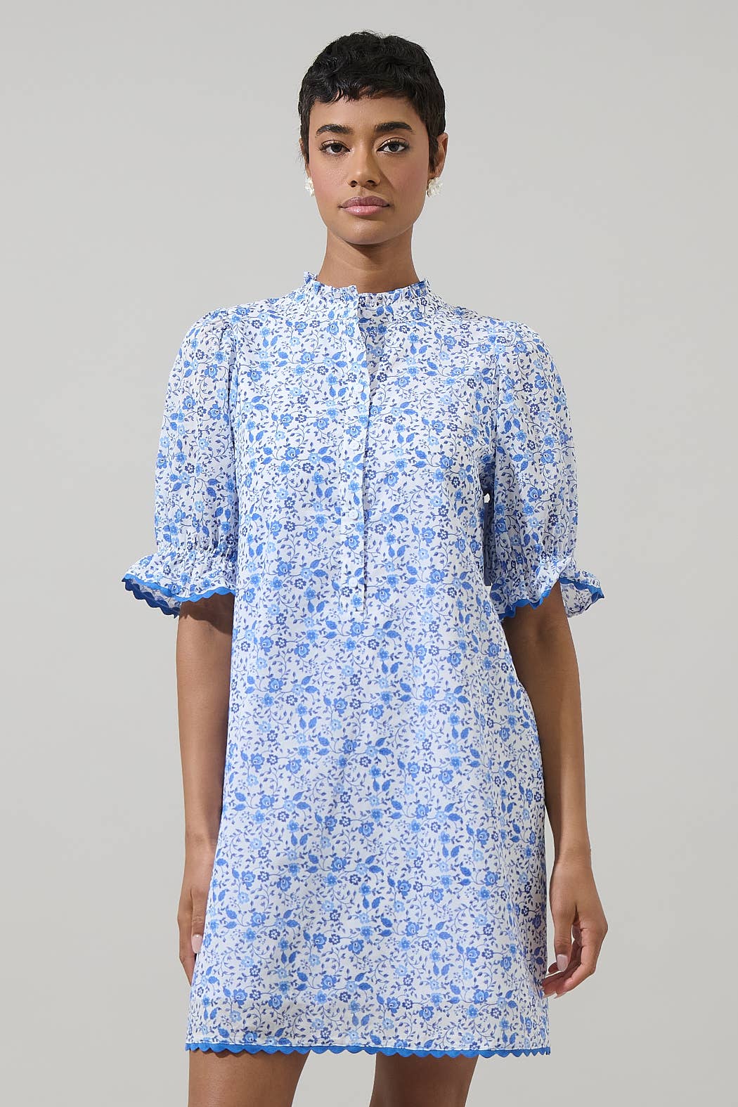 Maisie Floral Miana Button Up Dress in light blue and white floral, puffed sleeves, high collar, blue trim. Sizes XS-XL.